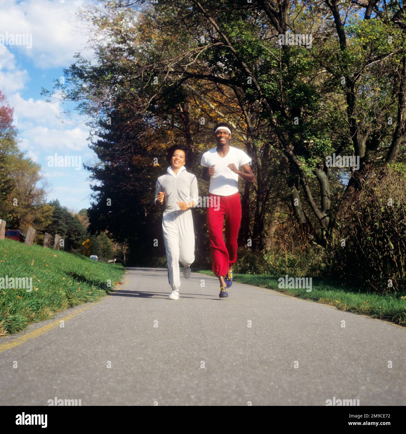 1980s ATHLETIC SMILING AFRICAN AMERICAN YOUNG COUPLE MAN AND WOMAN JOGGING TOGETHER IN PARK LOOKING AT CAMERA - ks21223 TEU001 HARS STYLE HEALTHY FRIEND YOUNG ADULT SAFETY ATHLETE PLEASED JOY LIFESTYLE SATISFACTION FEMALES MARRIED SPOUSE HUSBANDS RUNNERS HEALTHINESS ATHLETICS COPY SPACE FRIENDSHIP FULL-LENGTH LADIES PHYSICAL FITNESS PERSONS MALES ATHLETIC CONFIDENCE PARTNER EYE CONTACT GOALS ACTIVITY HAPPINESS PHYSICAL CHEERFUL STRENGTH AFRICAN-AMERICANS AFRICAN-AMERICAN LOW ANGLE RECREATION BLACK ETHNICITY PRIDE JOGGING SMILES JOG CONNECTION ATHLETES FLEXIBILITY FRIENDLY JOYFUL MUSCLES Stock Photo