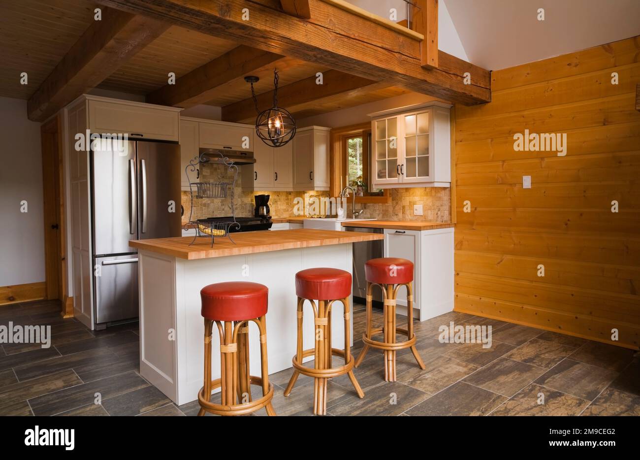 White wooden island with wood countertop and red leather and wood