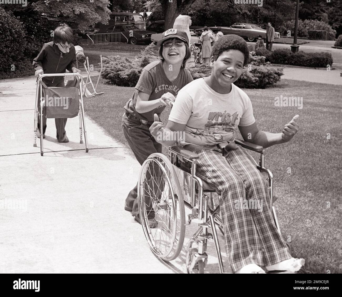 1970s SEVERAL SPECIAL NEEDS CHILDREN WALKING INTO SCHOOL SMILING