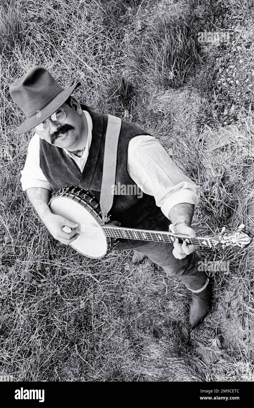 1960s 1970s 5 STRING BANJO MUSICIAN LOOKING UP AT CAMERA PLAYING BANJO WEARING HAT GLASSES MUSTACHE - m11727 HAR001 HARS MALES CONFIDENCE B&W NORTH AMERICA EYE CONTACT NORTH AMERICAN MUSTACHE PERFORMING ARTS HAPPINESS HIGH ANGLE MUSTACHES EXCITEMENT HANDSOME PRIDE UP FACIAL HAIR MUSICAL INSTRUMENT BANJO 5 STRING BLUEGRASS CREATIVITY YOUNG ADULT MAN BLACK AND WHITE HAR001 OLD FASHIONED Stock Photo