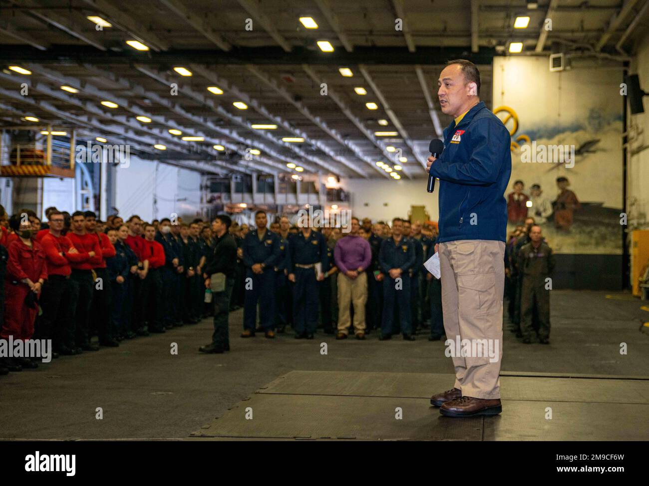 220516-N-DW158-1031 PACIFIC OCEAN (May 16, 2022) Capt. Fred Goldhammer, commanding officer of the U.S. Navy’s only forward-deployed aircraft carrier USS Ronald Reagan (CVN 76), speaks to Sailors during an all-hands call in the hangar bay. Ronald Reagan’s command team conducts all-hands calls to announce upcoming events, schedule changes, or important public service announcements to the ship’s crew. Ronald Reagan, the flagship of Carrier Strike Group 5, provides a combat-ready force that protects and defends the United States, and supports alliances, partnerships and collective maritime interes Stock Photo