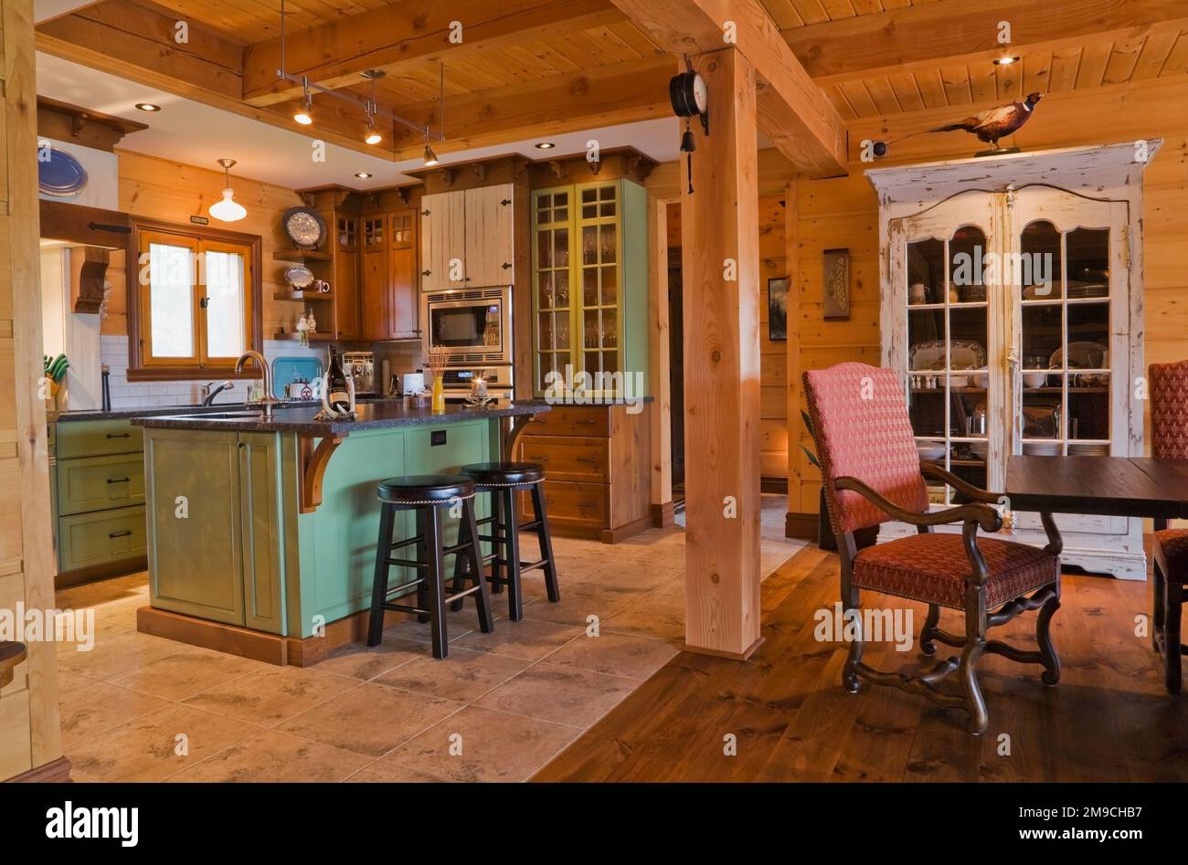 Green and brown wooden island with black granite countertop and black