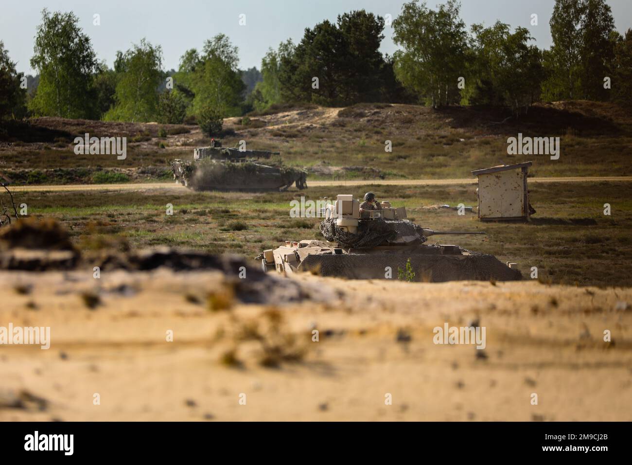 A U.S. Army M2A3 Bradley fighting vehicle assigned to the 1st Battalion, 8th Infantry Regiment, 3rd Armored Brigade Combat Team, 4th Infantry Division, and a German Puma infantry fighting vehicle assigned to the 212th Panzergrenadier Battalion, 21st Panzer Brigade, 1st Panzer Division, advance towards their target during a situational training exercise at Oberlausitz Training Area, Germany, May 16, 2022. Defender Europe 22 is a series of U.S. Army Europe and Africa multinational training exercises taking place in Eastern Europe. The exercise demonstrates U.S. Army Europe and Africa’s ability t Stock Photo