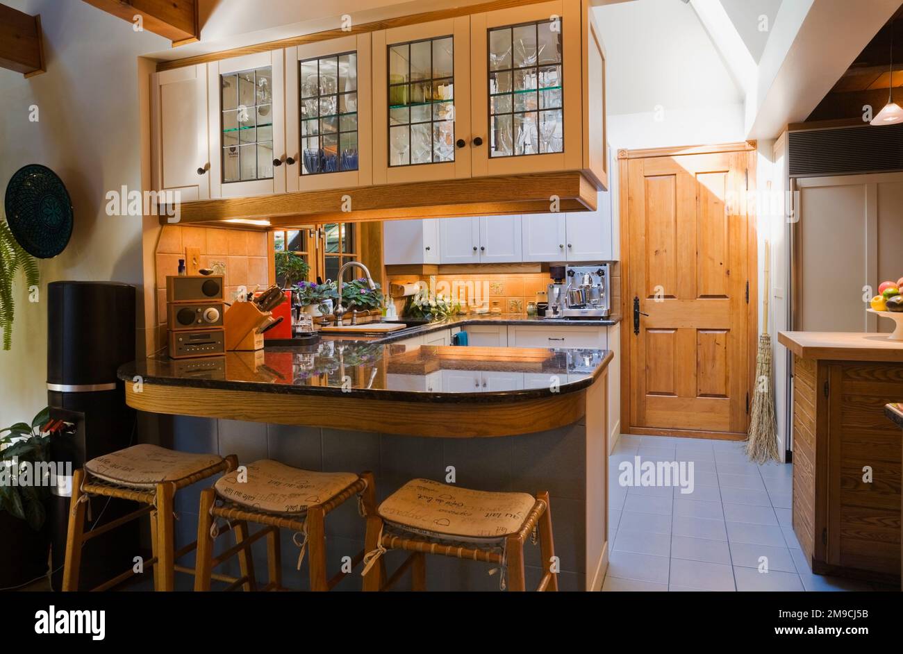 Kitchen with white wooden glass pane and bar with barstools