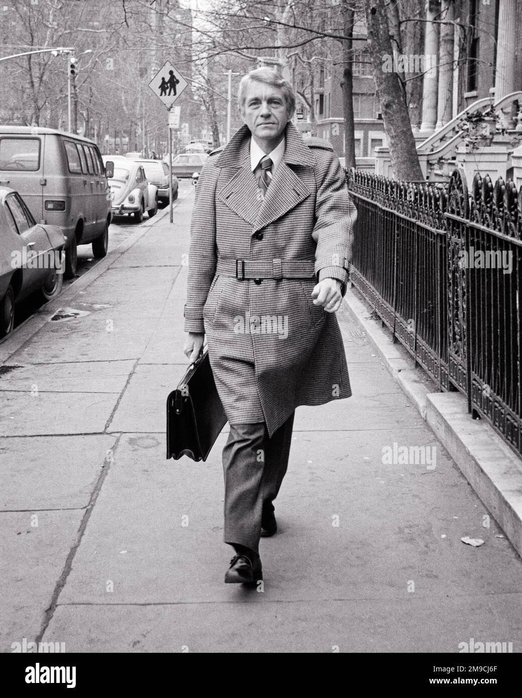 1970s UNSMILING MIDDLE-AGED MAN BUSINESSMAN SALESMAN WEARING BELTED WOOL COAT WALKING DOWN CITY STREET CARRYING BRIEFCASE - s20898 HAR001 HARS FACIAL STYLE WORRY LIFESTYLE SATISFACTION MOODY WOOL COPY SPACE FULL-LENGTH PERSONS MALES CONFIDENCE EXPRESSIONS TROUBLED MIDDLE-AGED B&W CONCERNED SADNESS MIDDLE-AGED MAN EYE CONTACT SUIT AND TIE SELLING LEADERSHIP PRIDE OPPORTUNITY MOOD OCCUPATIONS GLUM DAPPER STYLISH BELTED DETERMINED LAPELS MISERABLE SALESMEN BLACK AND WHITE CAUCASIAN ETHNICITY HAR001 OLD FASHIONED UNSMILING Stock Photo