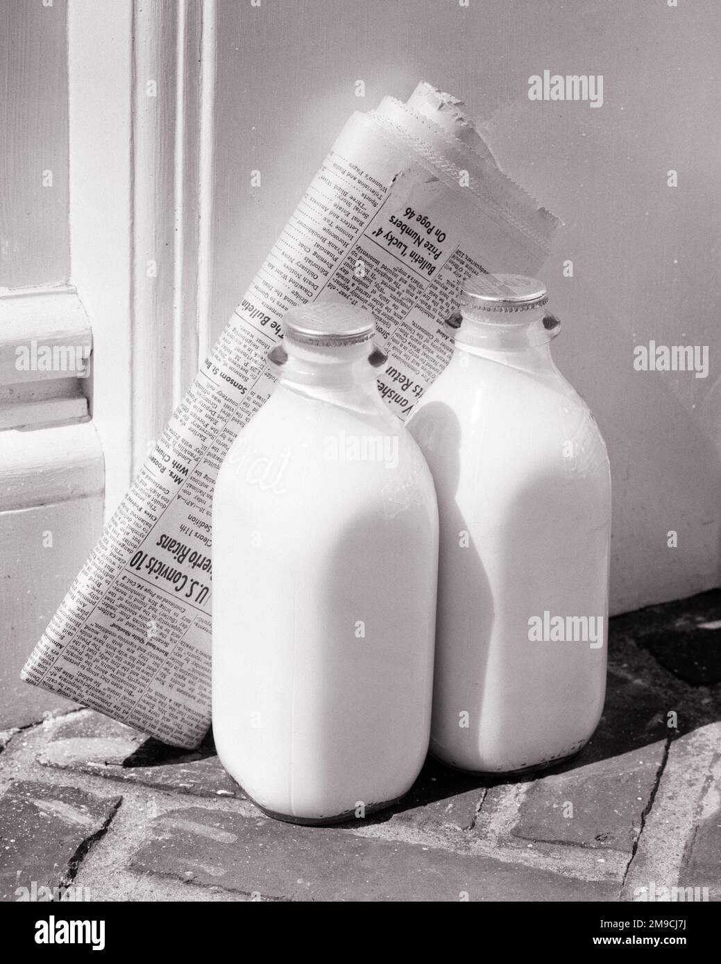 https://c8.alamy.com/comp/2M9CJ7J/1950s-two-glass-bottles-of-milk-and-a-newspaper-on-front-doorstep-a-regular-daily-delivery-s6810-har001-hars-nutritious-quarts-deliveries-doorstep-glass-bottles-protein-quart-regular-beverages-black-and-white-convenience-daily-har001-old-fashioned-2M9CJ7J.jpg