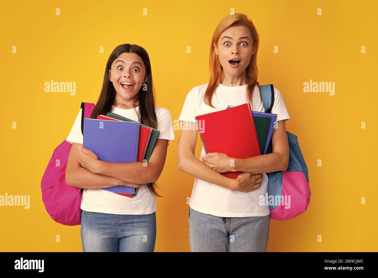 Portrait of expressive emotional teen girls. School, learning and education concept. Mother and daughter schoolgirls with school backpack and books Stock Photo