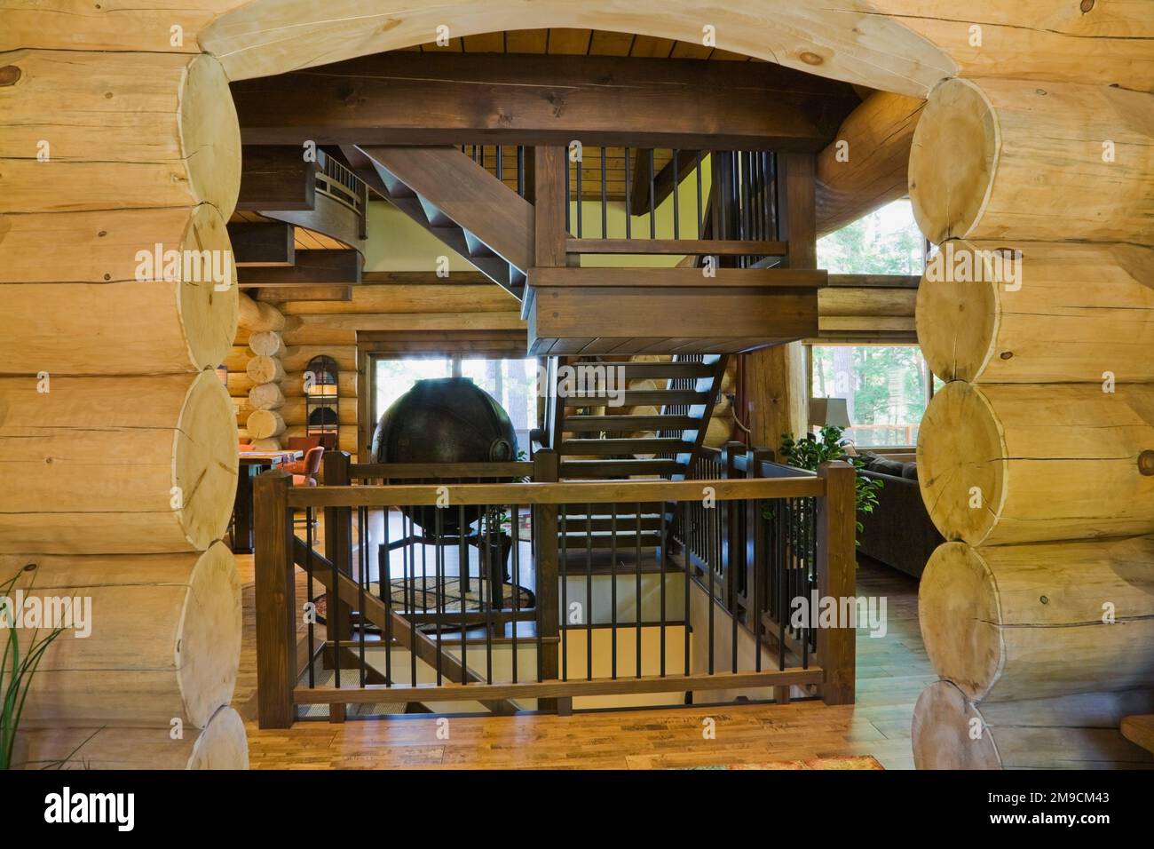 Wooden arch in main entrance hall and brown stained pine wood staircase