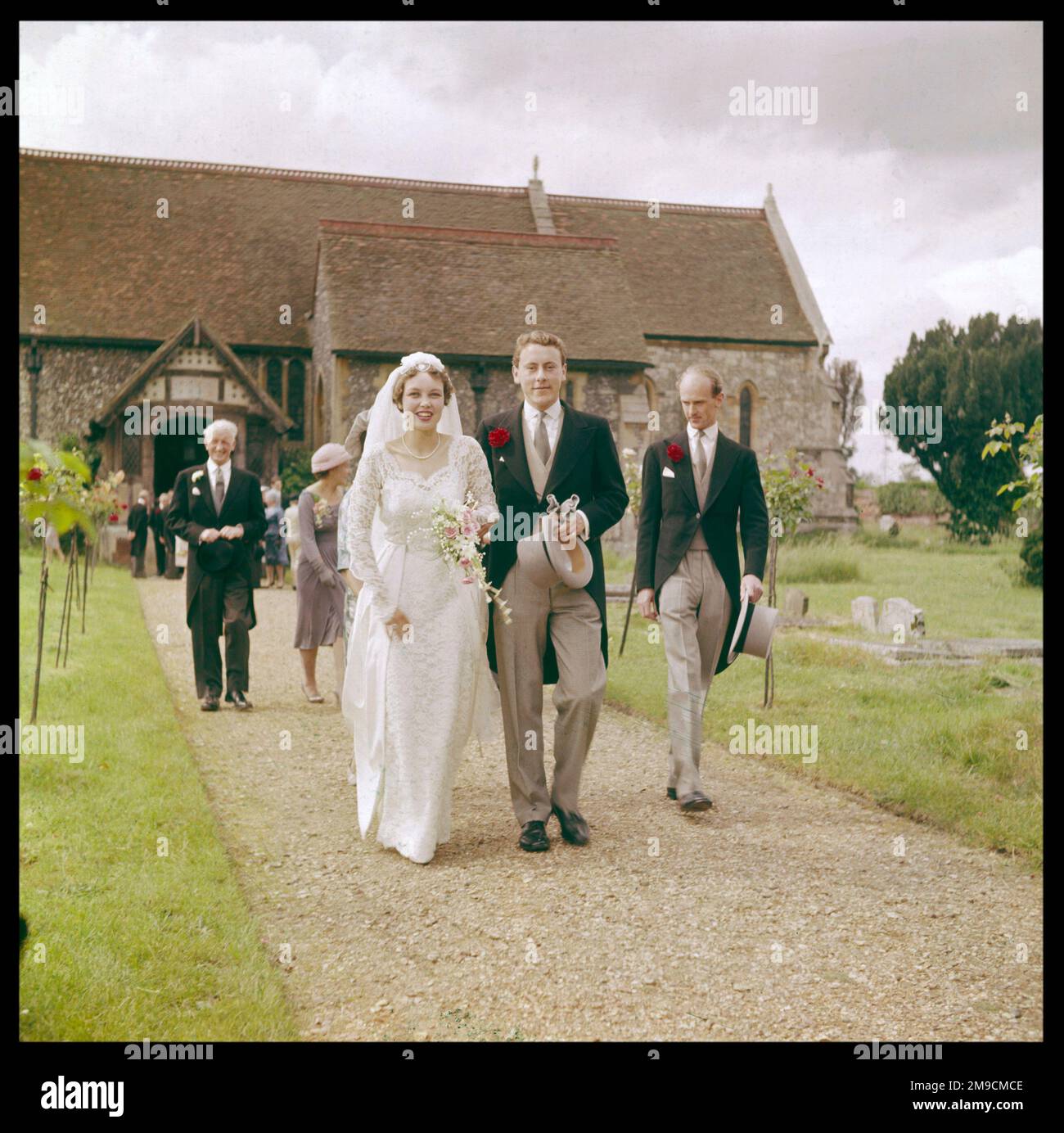 The bride, groom and best man leaving the church together. Stock Photo