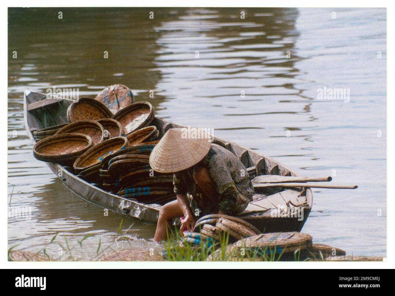 A Vietnamese woman inspects her fishing baskets; Hoi An. Stock Photo