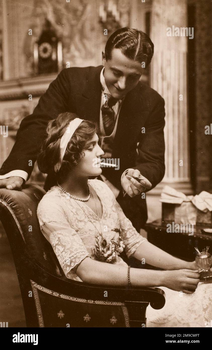 The Actro Robert Michaelis (as 'Freddy Fairfax') lights a cigarette for the actress Lily Elsie (as 'Alice') in the play 'The Dollar Princess'. Stock Photo