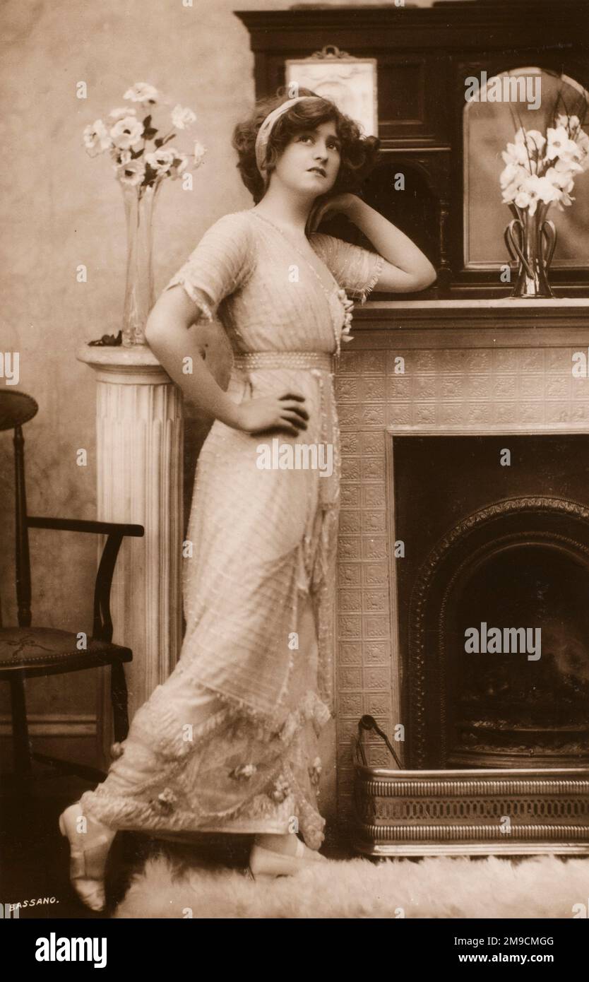 The actress Miss Gabrielle Ray as 'Daisy' in 'The Dollar Princess'. She leans with a wistful look against an elegant mantle piece in a very plush period interior Stock Photo