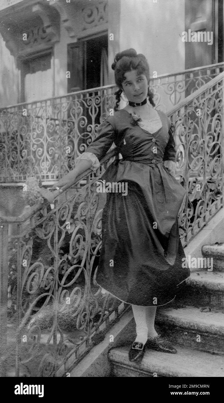A woman in costume standing on a staircase Stock Photo