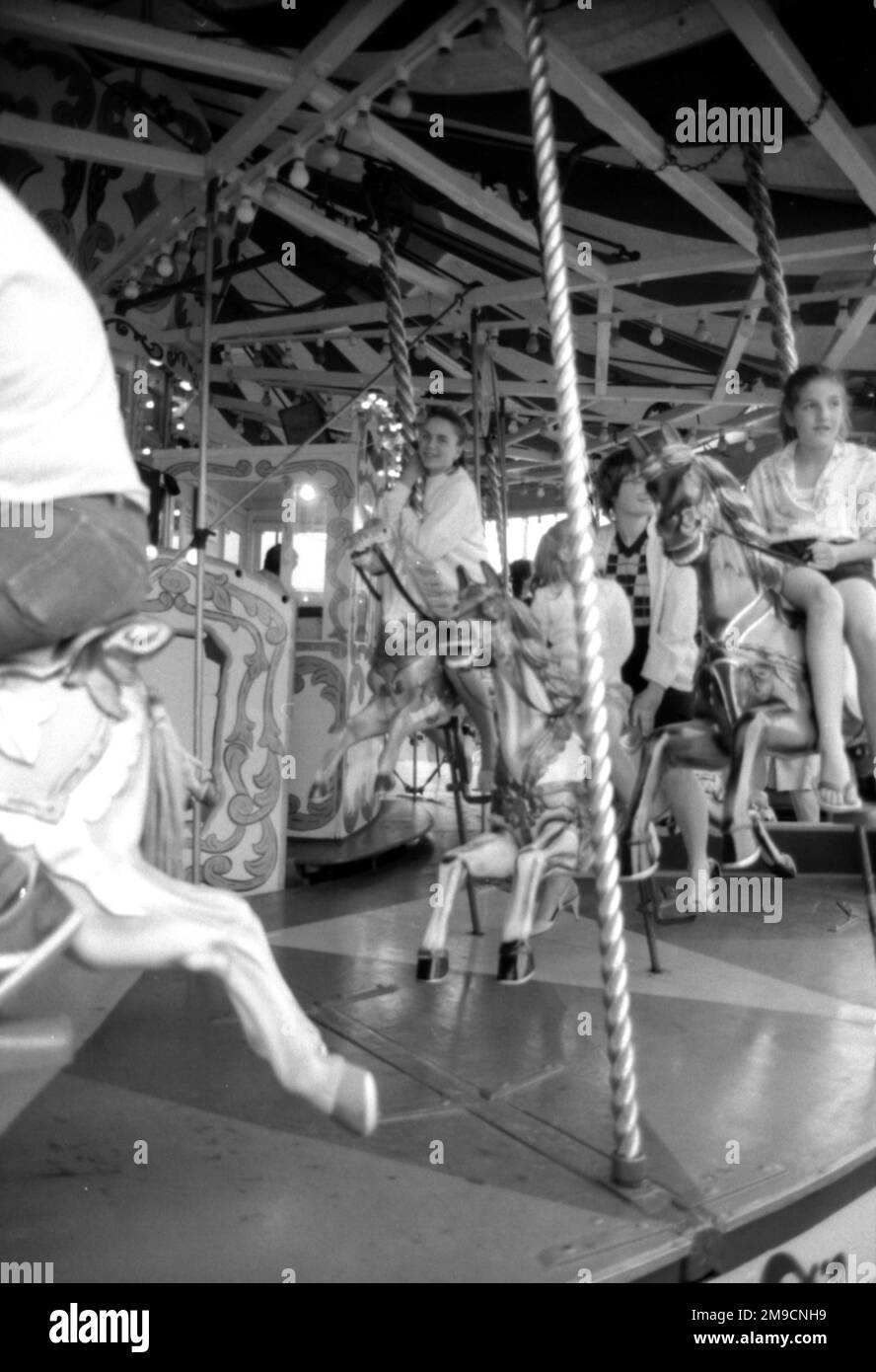 Children and adults ride a carousel at a Funfair in Surrey Stock Photo