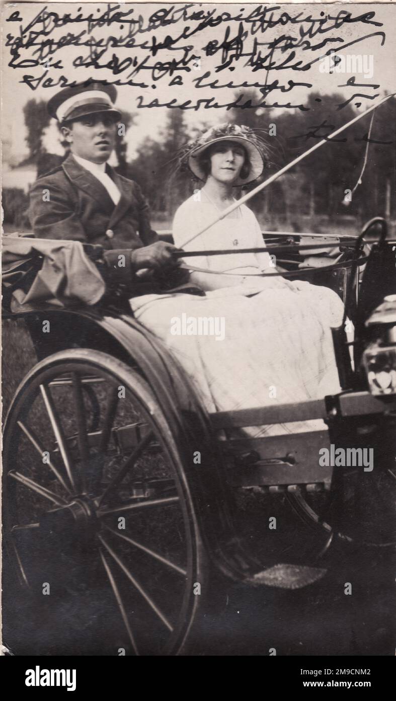 An elegant young woman in an open carriage with a coachman, Italy. Stock Photo