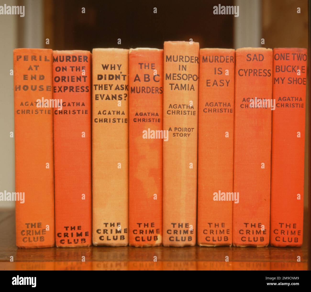 Eight UK first edition hardbacks, all in orange, of Agatha Christie crime novels. Stock Photo