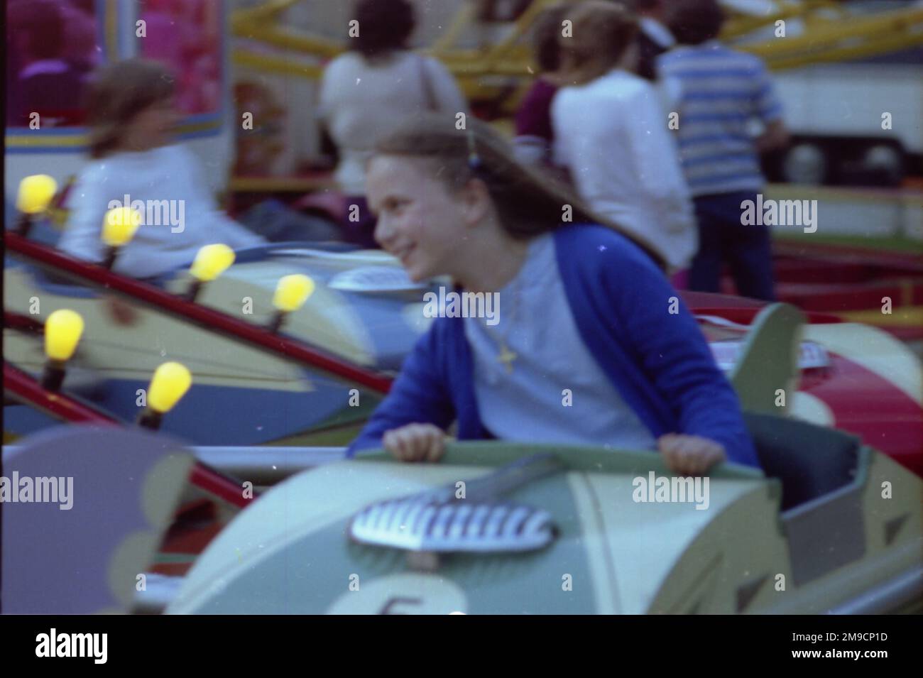 A little girl has lots of fun on a fairground ride at Godstone, Surrey. Stock Photo