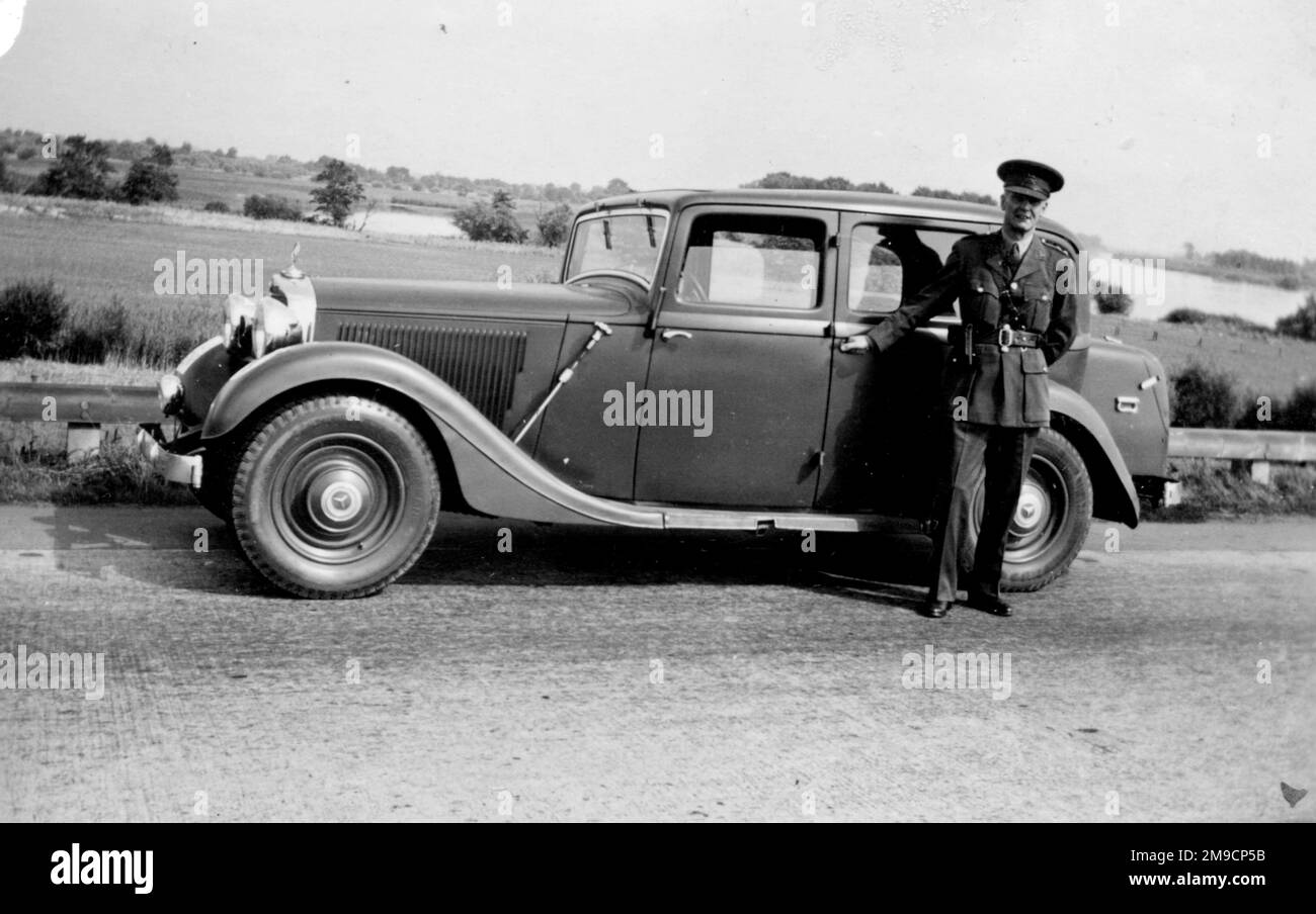 A British army officer poses at the side of his car on a German road near the Elbe Bridge, Hamburg, at the end of the Second World War. Stock Photo