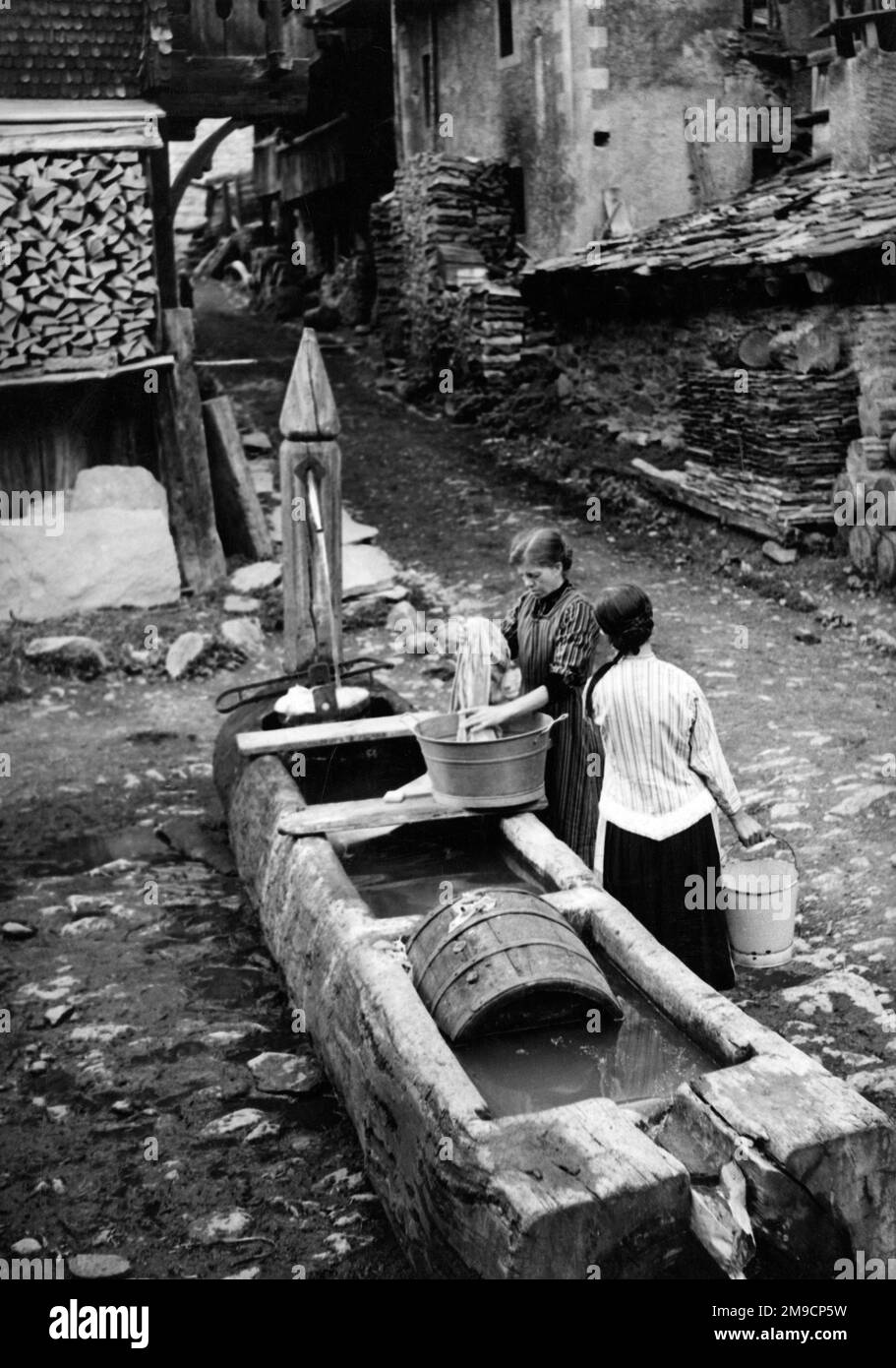 Kippel, Switzerland - Water Troughs. Water supply for the village is provided by hollowed-out tree trunks of the local larches. Despite severe winters, fresh spring water seldom freezes. Villagers do their laundry and scrub out milking utensils in the water troughs. Stock Photo