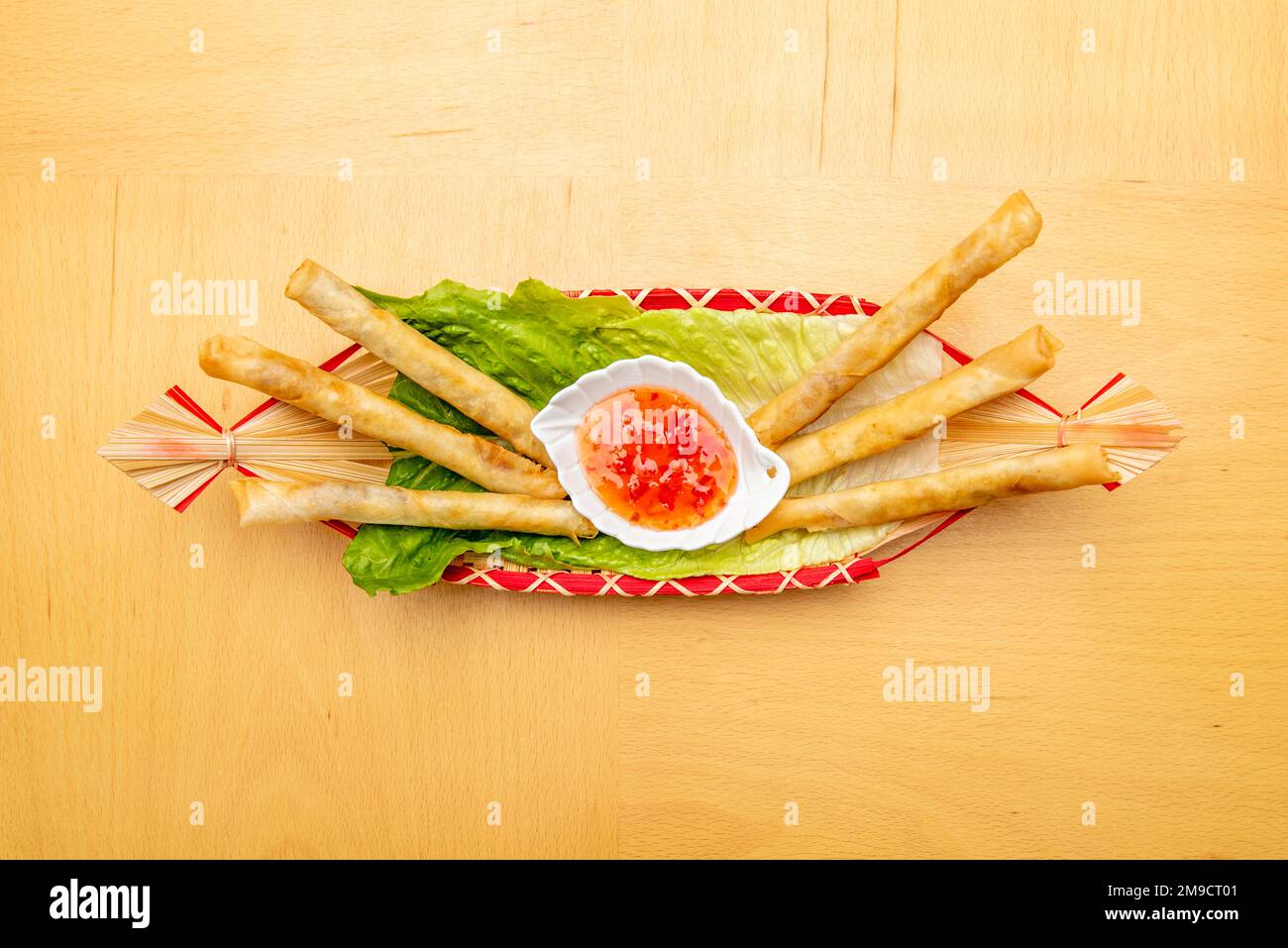 Pequeño rollo de masa de arroz, relleno de verduras, típico de la comida china con salsa agridulce para mojar Stock Photo
