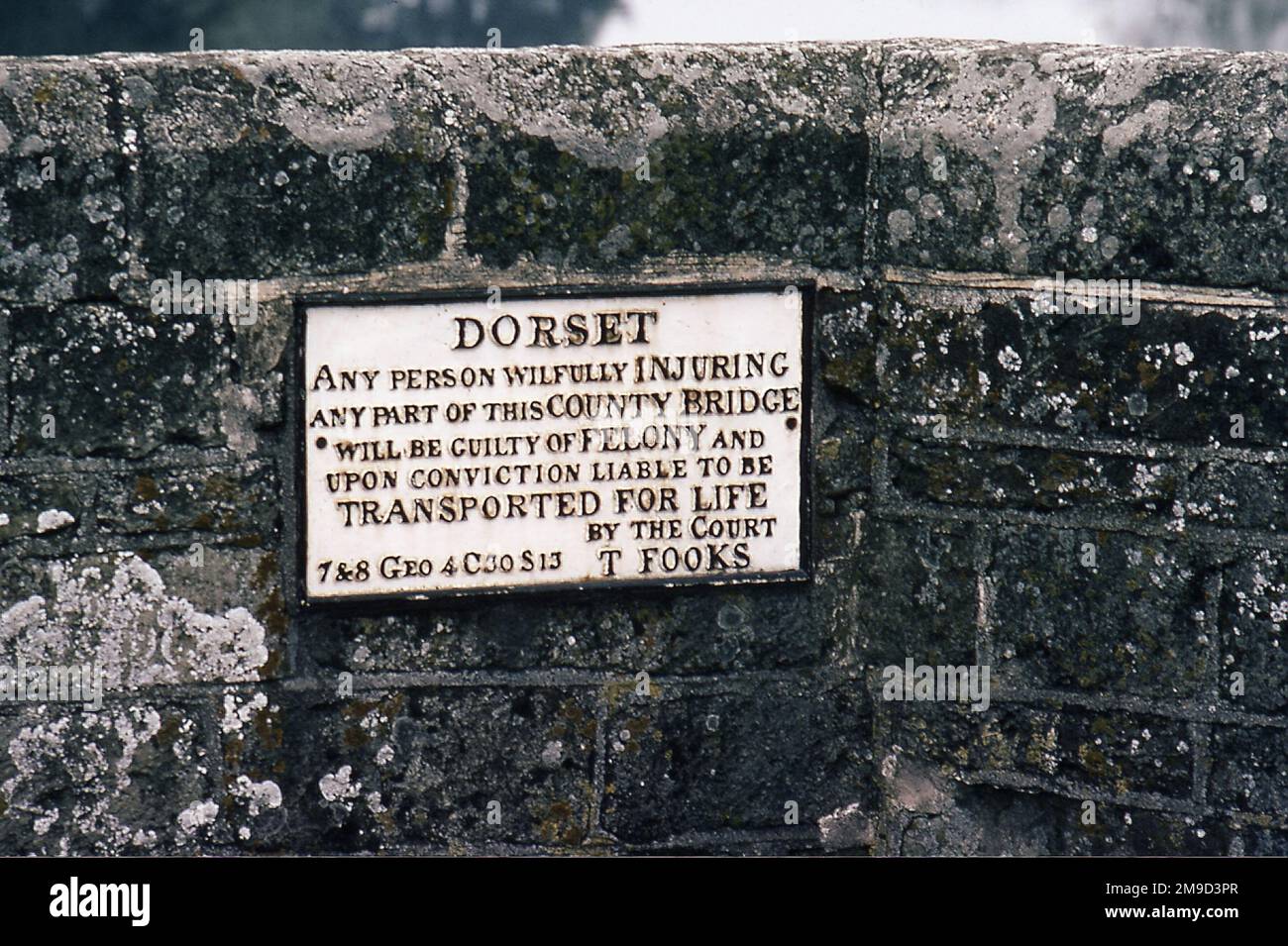 Sign warning of transportation for life as penalty for criminal damage, dating from reign of King George IV of England, 1820-1830, on a bridge near Sturminster Newton, Dorset, England. Stock Photo