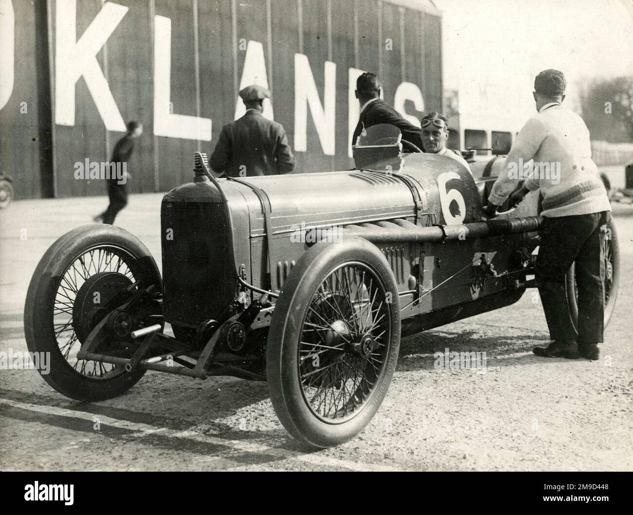 six-cyclinder 4 ltr Sunbeam (car 6) by buildings at Brooklands with Campbell at wheel. Stock Photo