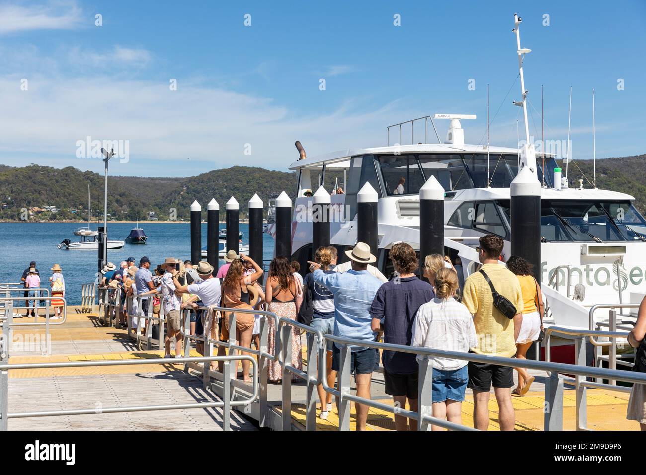 Holidaymakers and travellers at Palm Beach ferry wharf wait to board Fantasea ferry to Ettalong and Central Coast NSW, Pittwater,Sydney,Australia Stock Photo