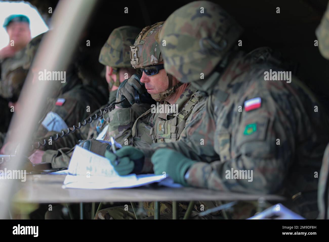 U.S. Army Maj. Robert Churchill, operations officer assigned to 1st Battalion, 68th Armor Regiment, 3rd Armored Brigade Combat Team, 4th Infantry Division, communicates via radio with the commanding officer and command sergeant major of the 1/68 during a multinational live-fire exercise that is part of Defender Europe at Mielno Range, Poland, May 17, 2022. Defender Europe 22 is a series of U.S. Army Europe and Africa multinational training exercises in Eastern Europe. The exercise demonstrates U.S. Army Europe and Africa’s ability to conduct large-scale ground combat operations across multiple Stock Photo