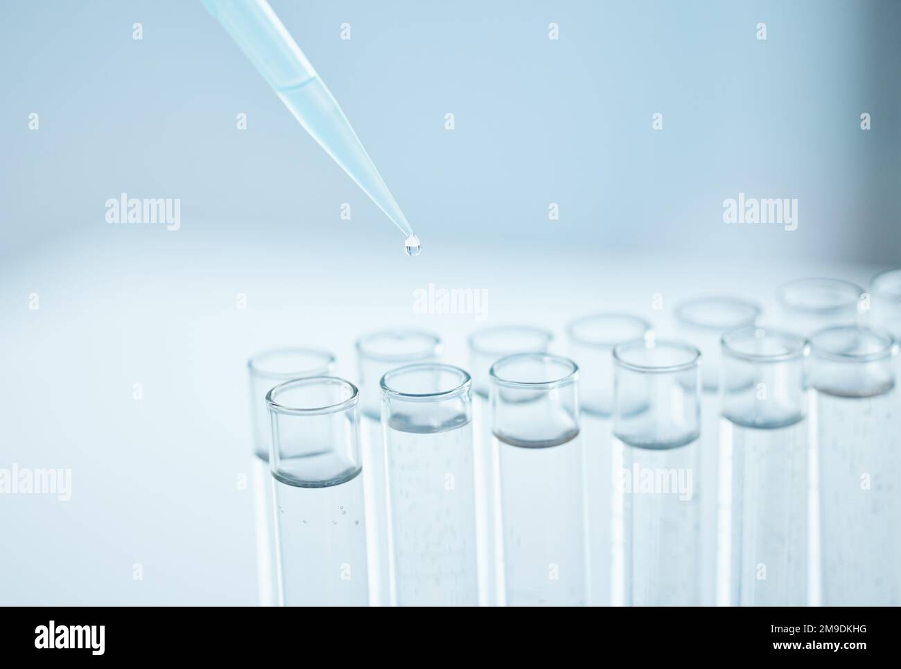 Be careful with those samples. Closeup shot of a dropper being used to fill test tubes in a lab. Stock Photo