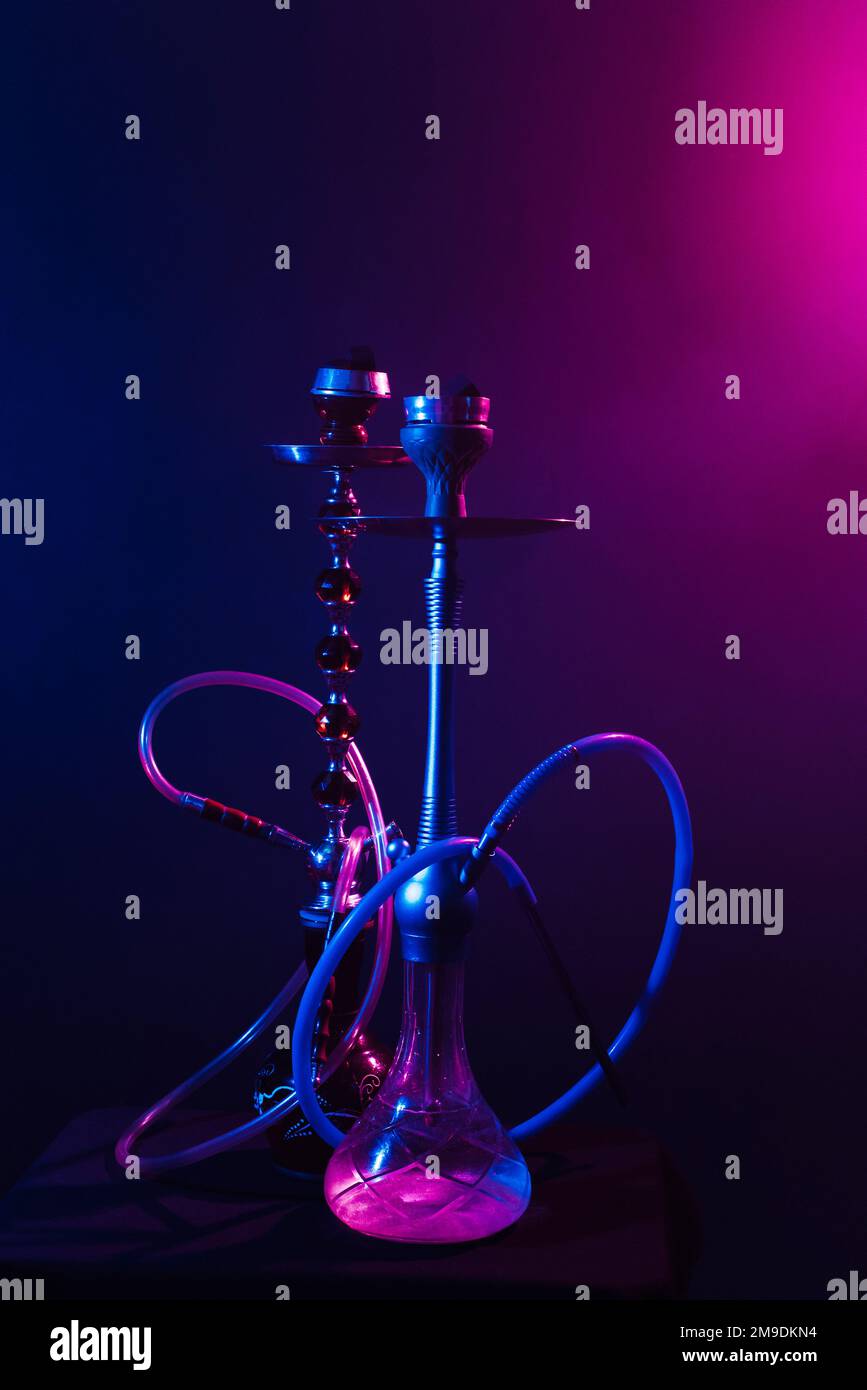 modern hookah, shisha on black background with neon lighting Stock