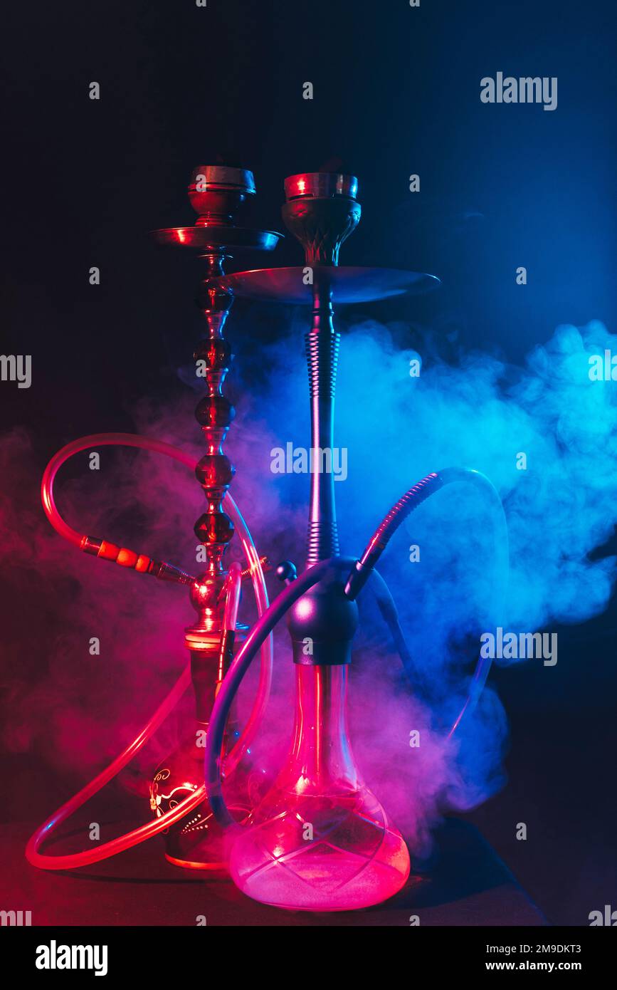 modern hookah, shisha on smoky black background with neon lighting