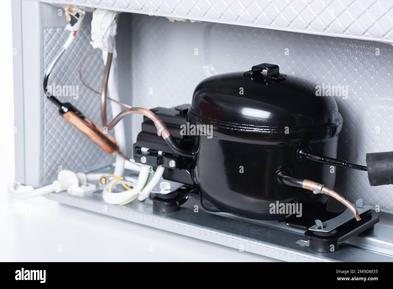 Close up refrigerator compressor mounted on the minibar. Stock Photo