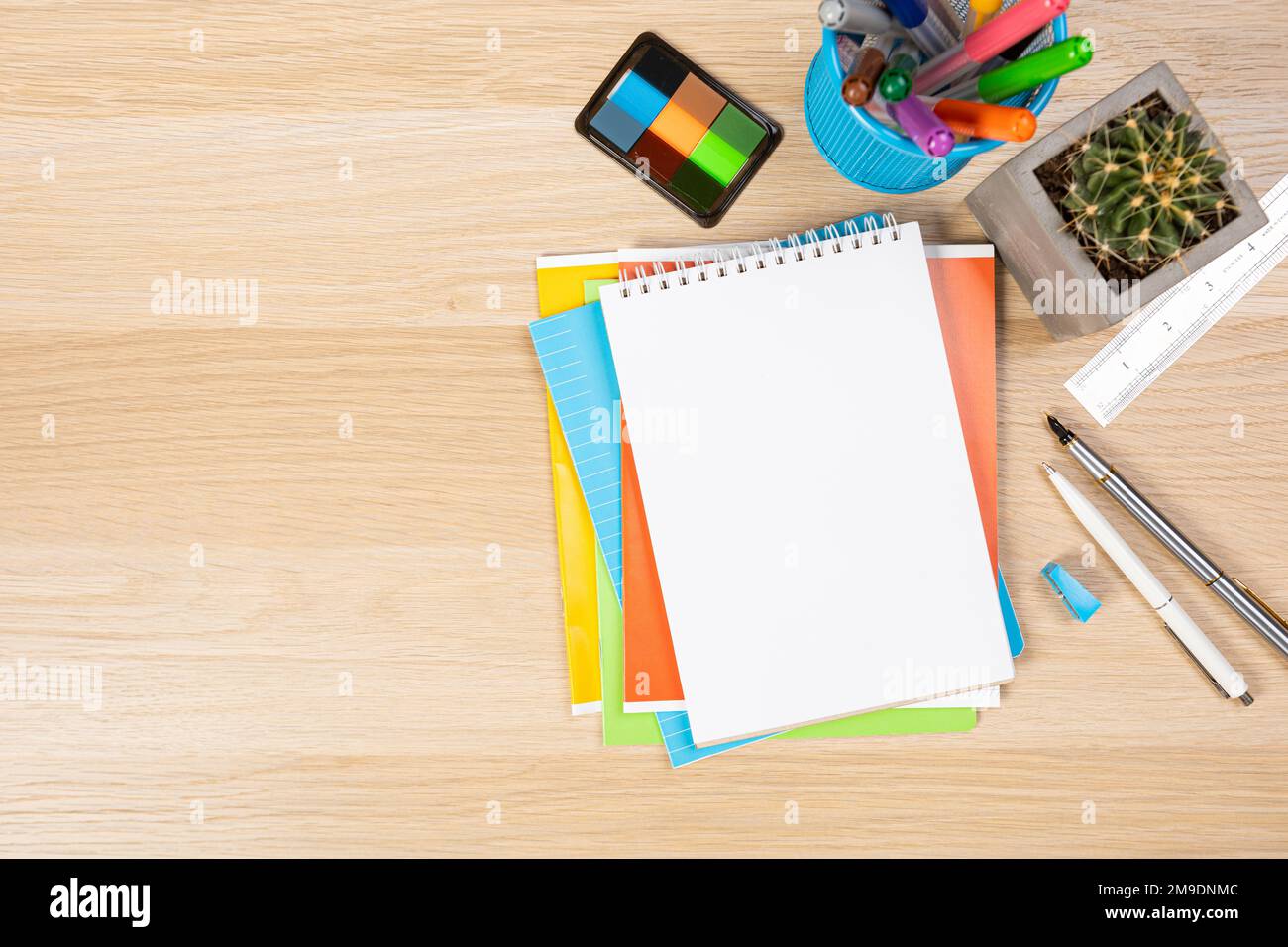 Back to school concept. Top view photo of notepads, pens, sharpeners, ruler, staplers, clips, markers and erasers on wooden table Stock Photo