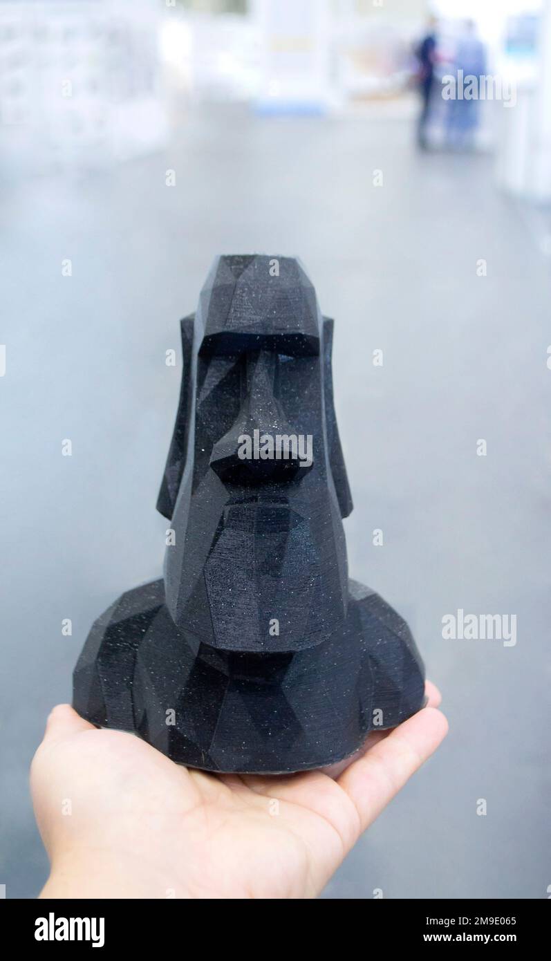 A person holding a model printed on a 3D printer from black plastic on ...