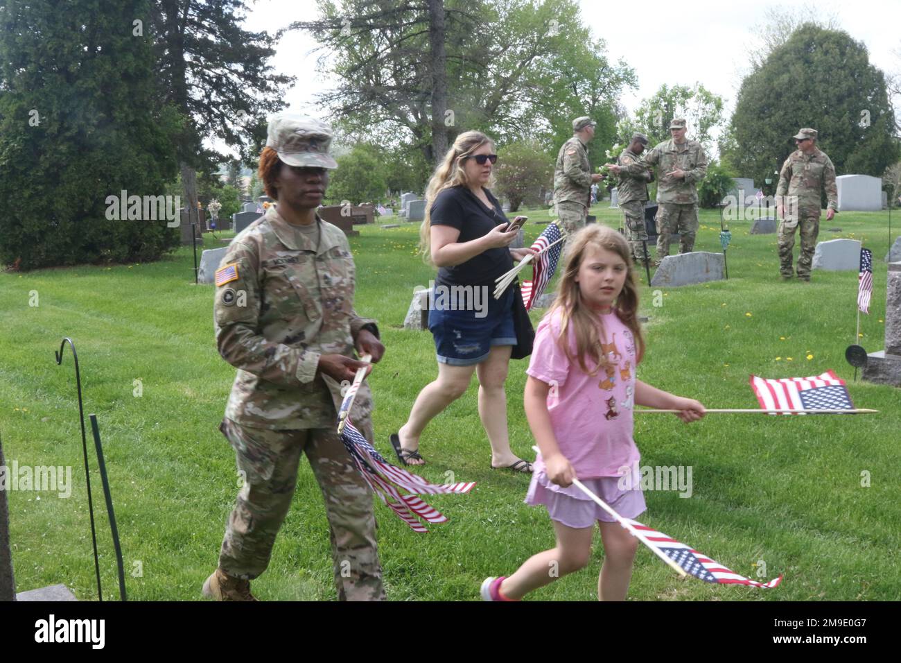 U.S. Army Reserve Sgt. 1st Class Andira McKinney, assigned to Headquarters and Headquarters Detachment, 88th Readiness Division, and Ella Rademan look for graves of American Veterans at the Woodlawn Cemetery. The cemetery was the final stop for the Ruck for the Fallen 5-kilometer ruck march in Sparta Wis., May 18, 2022. Stock Photo