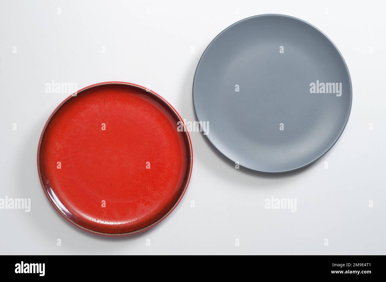 Red and gray empty plates on white table, top view Stock Photo