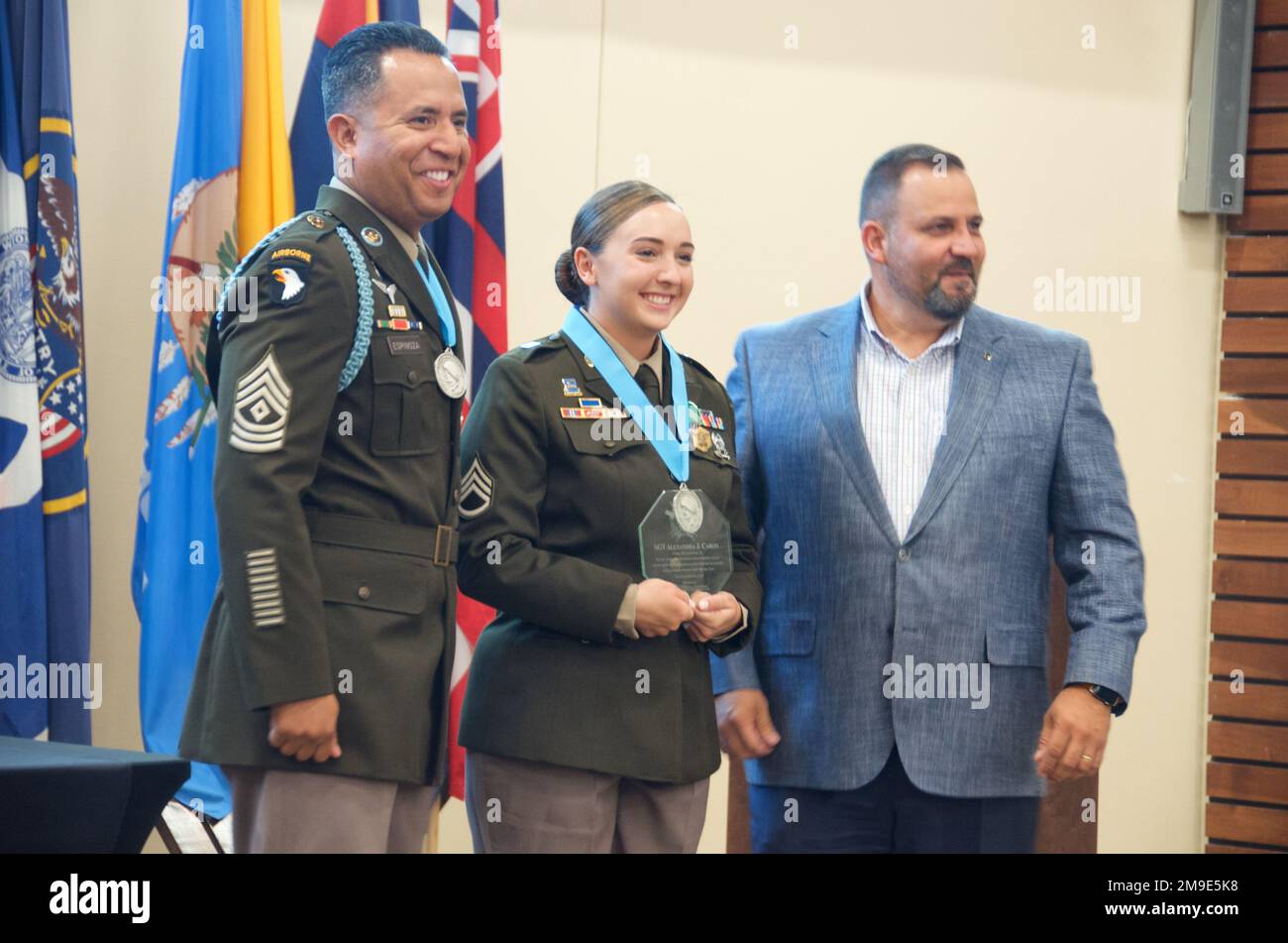 Staff Sgt. Alexandra Caron, 8th Engineer Battalion, 2nd Armored Brigade Combat Team, 1st Cavalry Division, receives the Sergeant Audie Murphy medallion and an award from Fort Hood National Bank during a Sergeant Audie Murphy Club induction ceremony at Fort Hood, Texas, May 18, 2022. SAMC President First Sgt. Mario Espinoza and Fort Hood National Bank Vice President Fernando Fernandez are pictured with the new awardee. Stock Photo