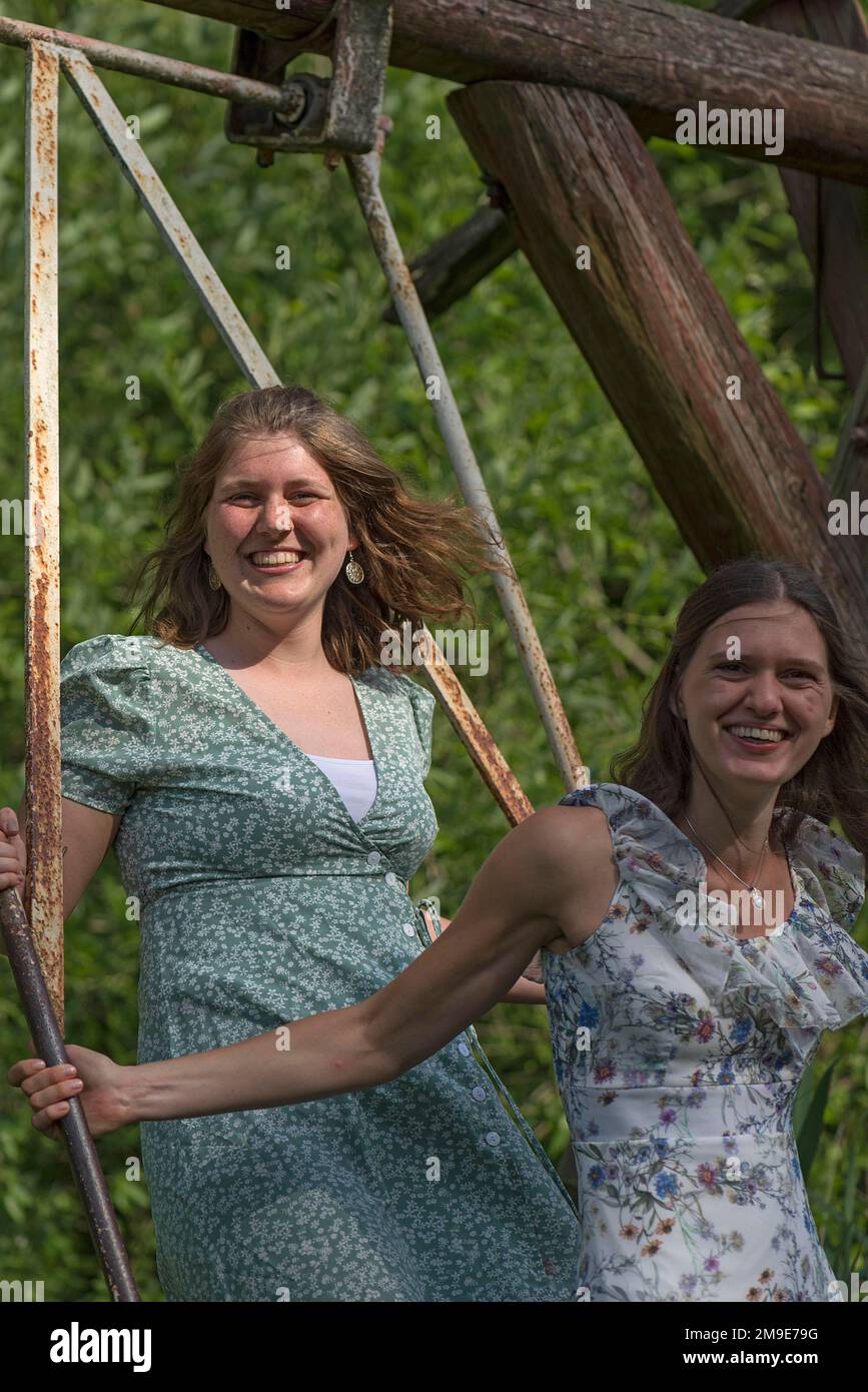 Two young girls swinging, Mecklenburg-Western Pomerania, Germany Stock Photo