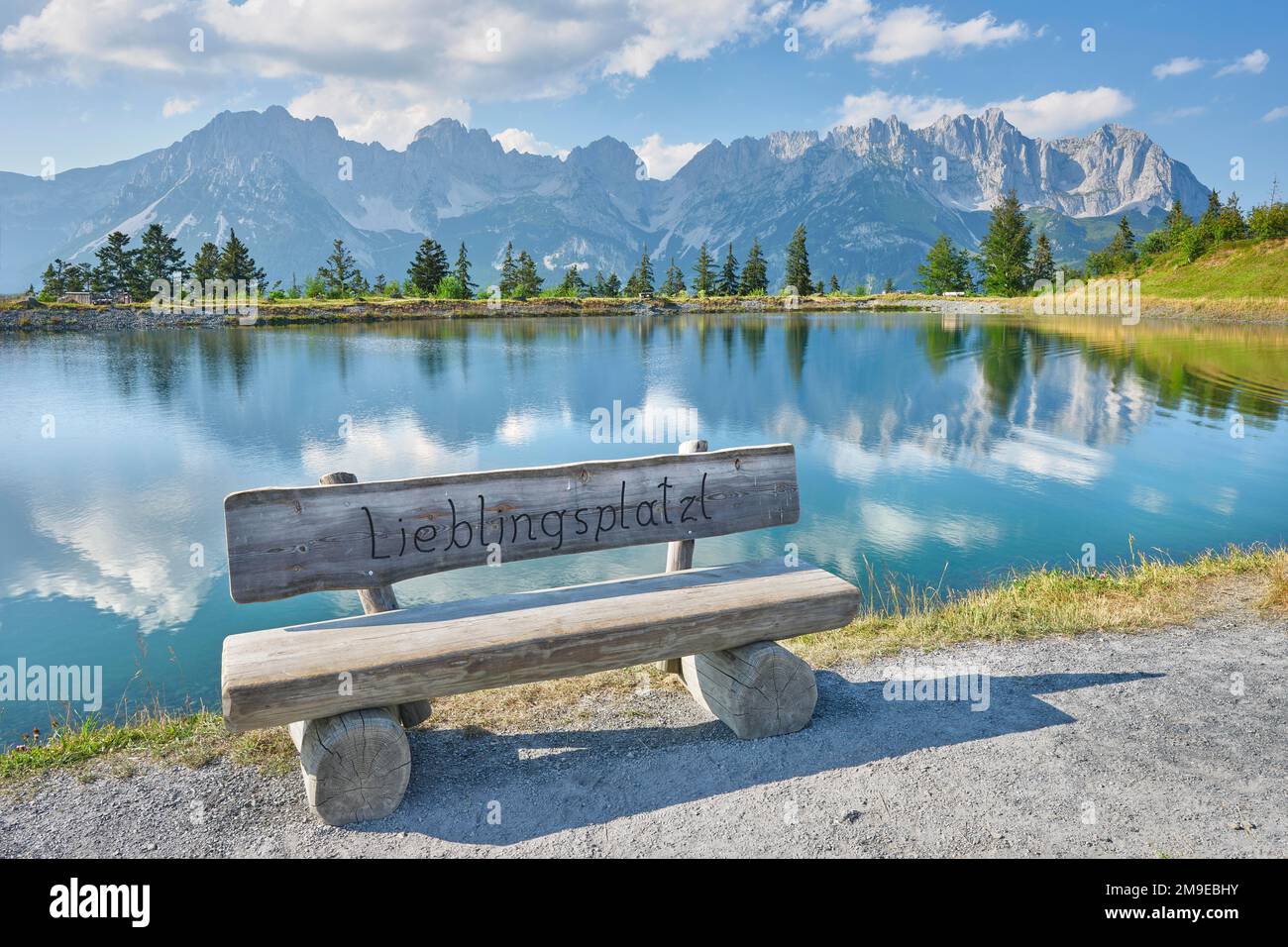 Bench in front of Astbergsee with reflection of the mountain panorama, Wilder Kaiser, Ellmau, Tyrol Stock Photo