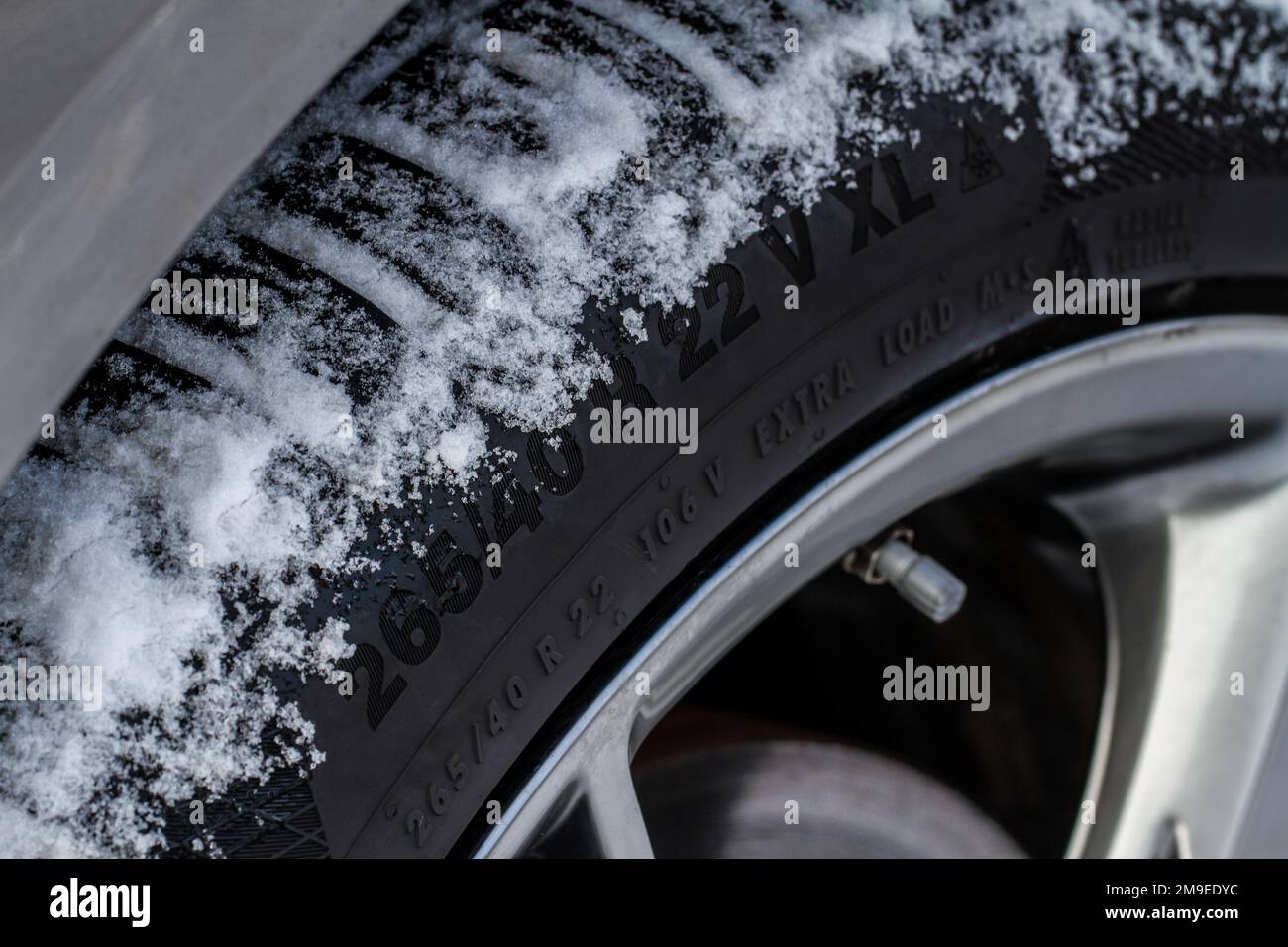 Close up view of snowy tire with tire width, height and wheel diameter