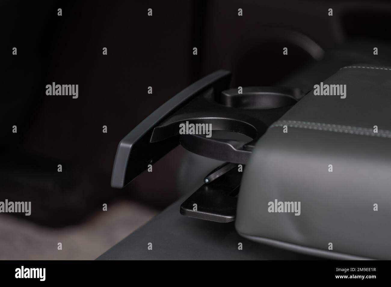 Modern car cup holder for rear seats row. Armrest in the car with cup