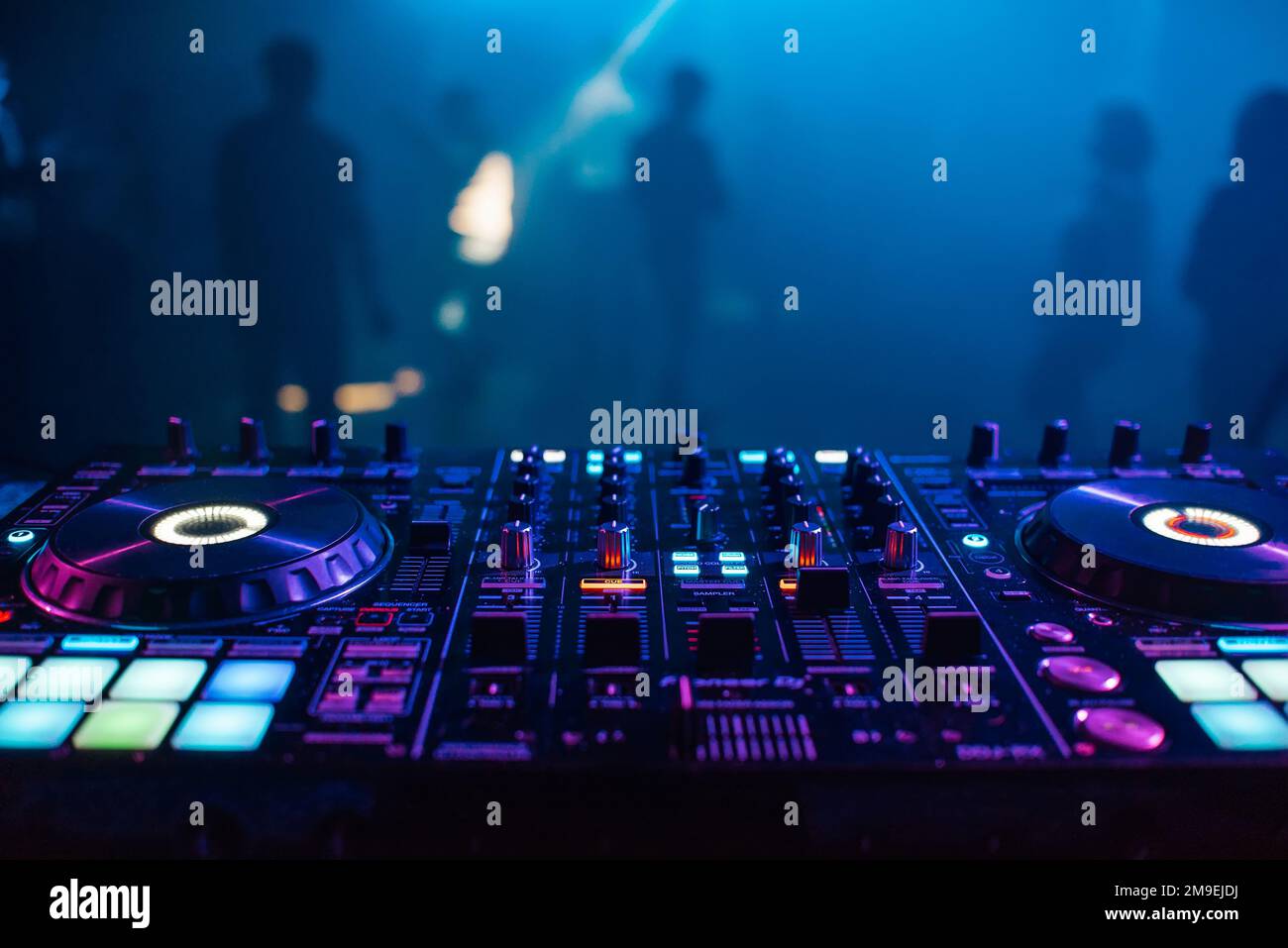 DJ mixer on the table background the night club and dancing people Stock Photo Alamy
