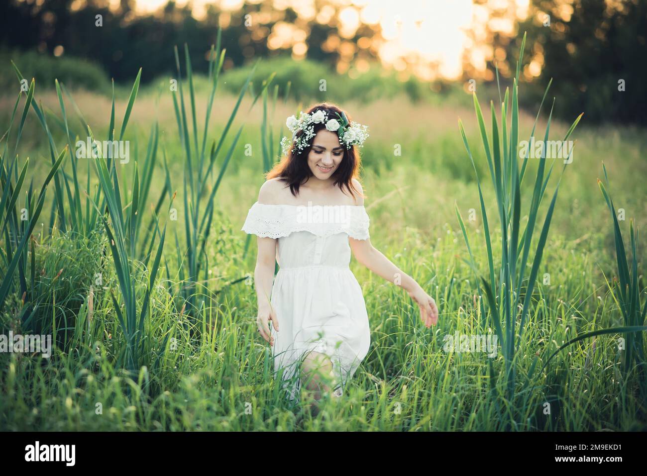 happy attractive girl in white dress smiling happily in summer field ...