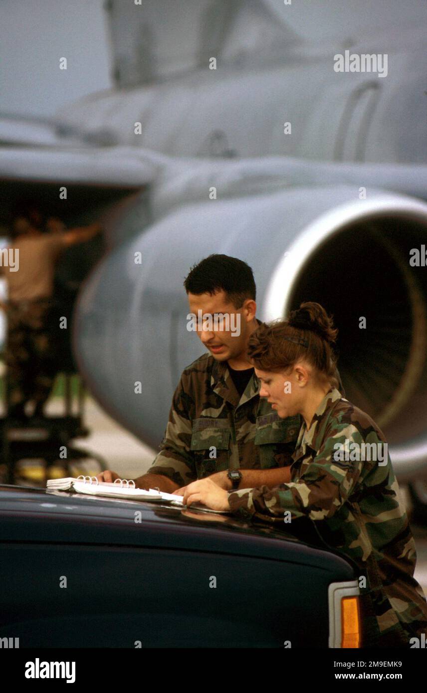 US Air Force SENIOR AIRMAN Jason Guidry and USAF STAFF Sergeant Cindy Hill, crew chiefs, review safety evacuation routes before they pump fuel from a KC-135 tanker's cavernous fuel tanks. The tanker had just arrived on base, and the airmen were checking the tanks for leaks. This photograph is part of the November 1999 AIRMAN Magazine article 'In the Right Place'. Base: Macdill Air Force Base State: Florida (FL) Country: United States Of America (USA) Stock Photo