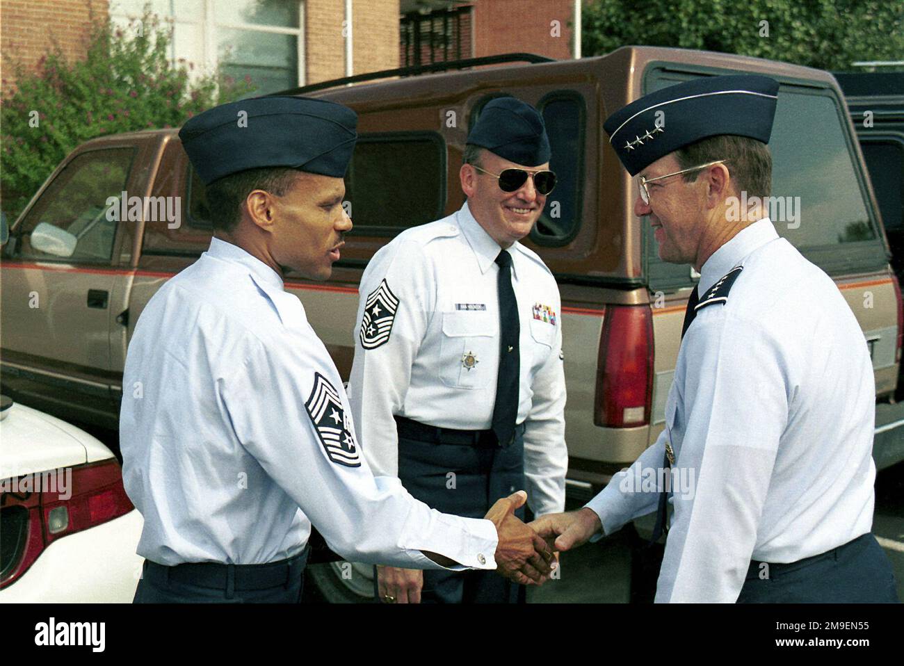 Right side profile medium close-up shot as US Air Force Command (AMC) CHIEF MASTER Sergeant Francis (left), 89th Air Wing, Andrews Air Force Base, Maryland, shakes hands with USAF General Tony Robertson (right), Air Mobility Command Commander. AMC Command CHIEF MASTER Sergeant Kenneth Van Holbeck (center) looks on. General Robertson and CHIEF Van Holbeck arrived at the 89th Air Wing Headquarters building for a tour briefing at Andrews AFB, Maryland. Base: Andrews Air Force Base State: Maryland (MD) Country: United States Of America (USA) Stock Photo