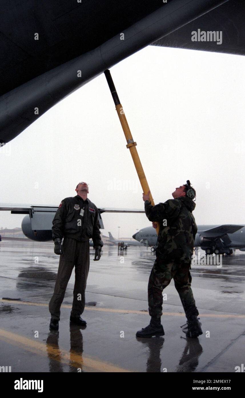Medium shot, STAFF Sergeant Tim Leahy, USAF, demonstrates to First Lieutenant Ron Kennedy, USAF, the proper way to place a tail stand on the back of a KC-135 at Grand Forks Air Force Base, North Dakota, on 25 February, 2000. The tail stand is used to balance the aircraft during refueling procedures and is a necessary part of the crew servicing exercise which was taking place on the Charlie ramp at the base. Sergeant Leahy is a Crew CHIEF with the 319th Aircraft Generation Squadron and Lieutenant Kennedy is a Copilot with the 911th Air Refueling Squadron. Subject Operation/Series: CRISIS LOOK 0 Stock Photo