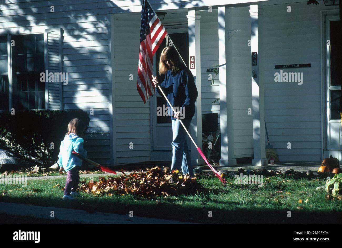 Barbara Helm, wife of US Air Force Major Alfred Helm, and daughter, Hannah, rake leaves in front of their on-base house. From the March 2000 AIRMAN Magazine article 'Based in Beantown,' depicting how good an assignment to Hanscom AFB, Massachusetts can be up in the Northeast. Base: Hanscom Air Force Base State: Massachusetts (MA) Country: United States Of America (USA) Stock Photo