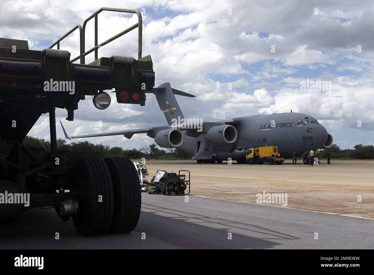 A rear view medium shot of a partially shown 25K Loader is ready for use at Hoedspruit AFB, South Africa, after delivery from the 721st Air Mobility Squadron at McGuire Air Force Base, New Jersey, by a C-17A Globemaster III, from the 437th Airlift Wing at Charleston Air Force Base, South Carolina. The equipment will be used during 'Operation Atlas Response' to support cargo loading of aircraft distributing relief supplies in Mozambique. Subject Operation/Series: ATLAS RESPONSE Base: Hoedspruit Air Force Base Country: South Africa (ZAF) Stock Photo