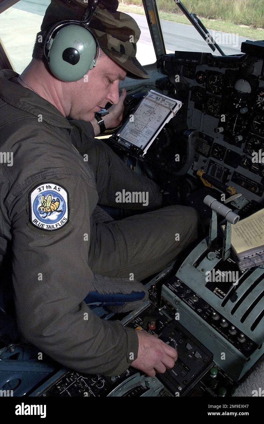 Right side profile medium close-up as USAF MASTER Sergeant David Greene, a C-130 flight engineer from the 37th Airlift Squadron, 86th Airlift Wing, Ramstein Air Base, Germany, performs a pre-flight operational check before departing Hoedspruit Air Force Base, South Africa, to deliver U.S. personnel and supplies (personnel and supplies not shown) to Beira, Mozambique, during Operation Atlas Response. The U.S. aircraft are deployed to South Africa to provide humanitarian relief to the people (not shown) forced from their homes in the flooded regions of Mozambique. Subject Operation/Series: ATLAS Stock Photo