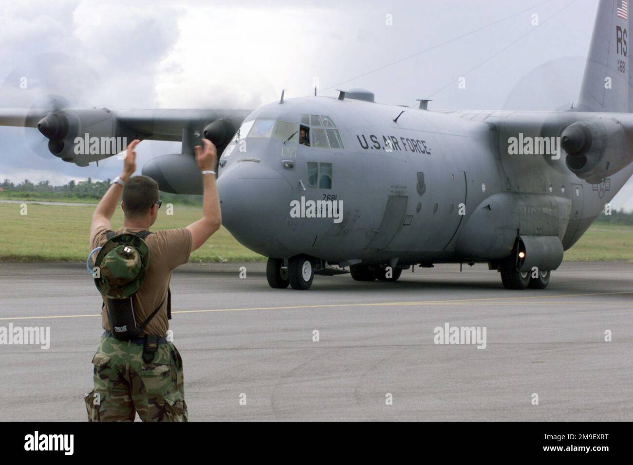 Rear view medium shot over the right shoulder as US Air Force Captain Jeff Burrell, Officer in Charge of Logistics Plans and Cargo Movement, from Headquarters United States Air Forces Europe, Logistics Branch, Ramstein Air Base, Germany, marshalls in a C-130 Keen Sage, aerial assessment aircraft, that allows the Air Force to provide needed color video imagery of the flood damaged roads and lines of communication, to the Government of Mozambique, Non Government Orginizations, and International Relief Orginizations, at the International Airport at Maputo, Mozambique, Africa on 16 March 2000. The Stock Photo